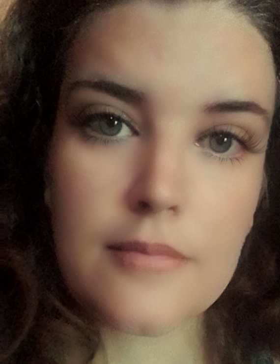 happy adult woman reading book with interest on street